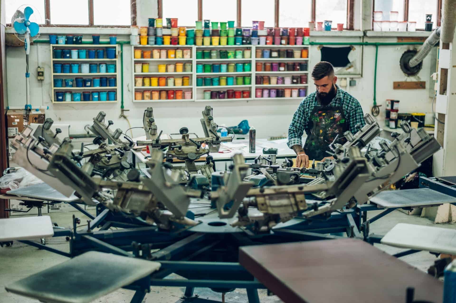 Male Worker Pressing Ink On Frame While Using The Printing Machi